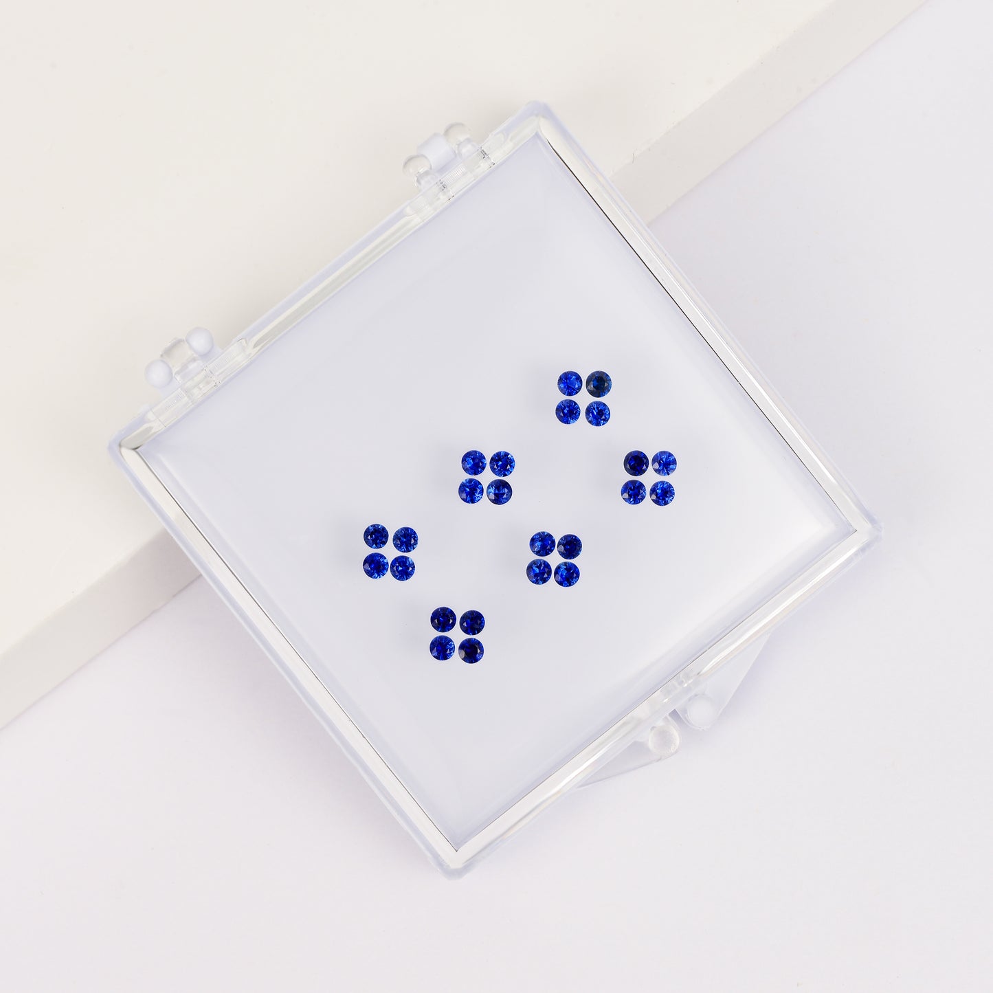 Four-leaf clover ring set with round sapphire stones in a box
